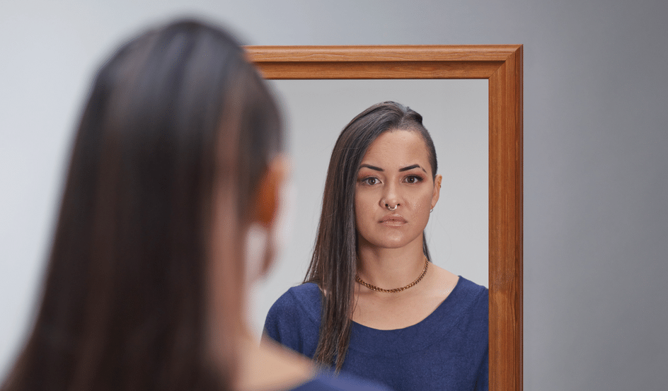 A women looking at the camera through a mirror